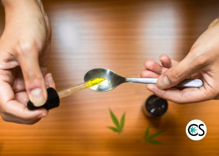 hands measuring out CBD into a spoon