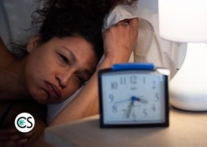 woman with insomnia staring at clock